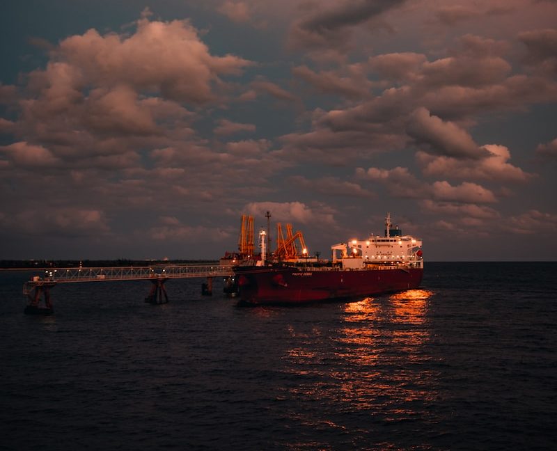 red and white ship on sea under cloudy sky during daytime